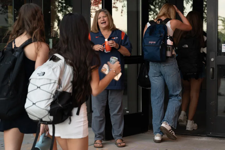 Kerry Lane, principal of Olathe East High School, greets students as they enter the building.