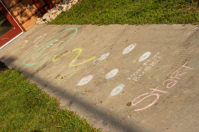 Chalk art from kindergarteners’ first day of school at Bentwood Elementary encourages students to make a playful entrance into the classroom.