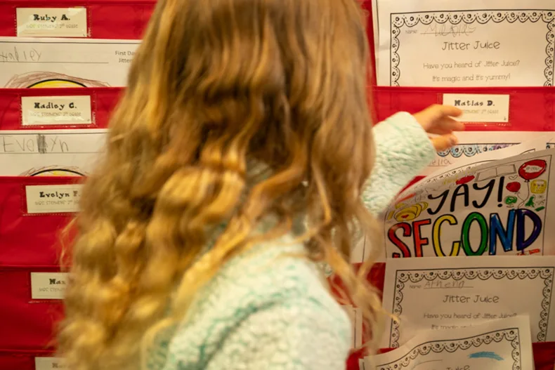 A student in Melanie Stephen’s second grade class at Bentwood Elementary picks out a coloring sheet from her file.