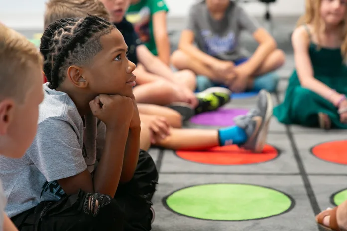 Student intently listens to teacher on first day of school.
