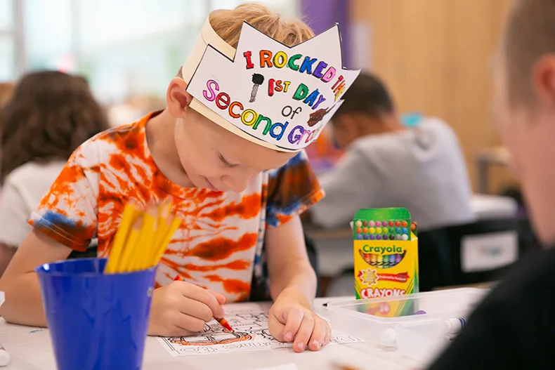 A student colors on his first day of school.
