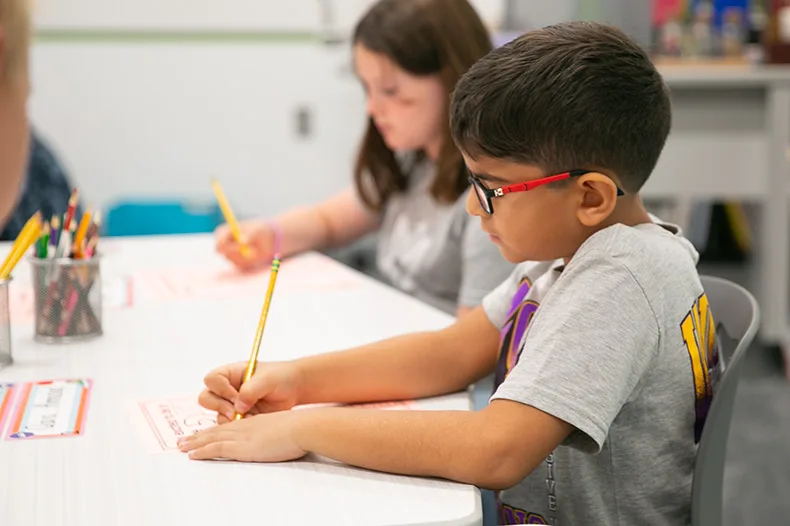 A student writes on the first day of school.