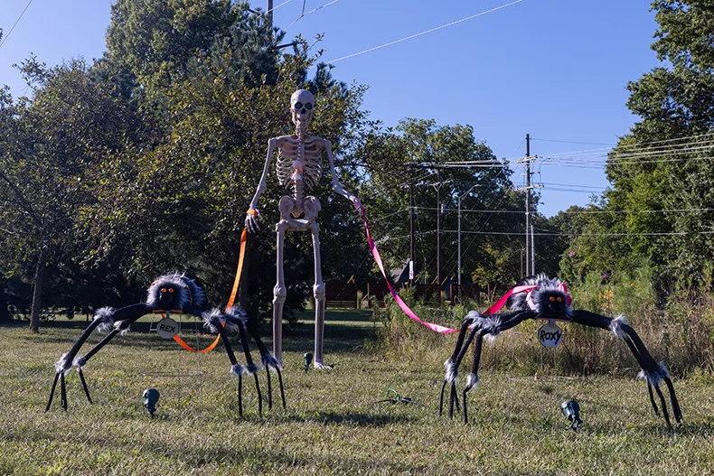 A giant skeleton walks two spiders named “Rex” and “Roxy” in a yard across from Meadowbrook Park on Somerset Drive in Prairie Village.