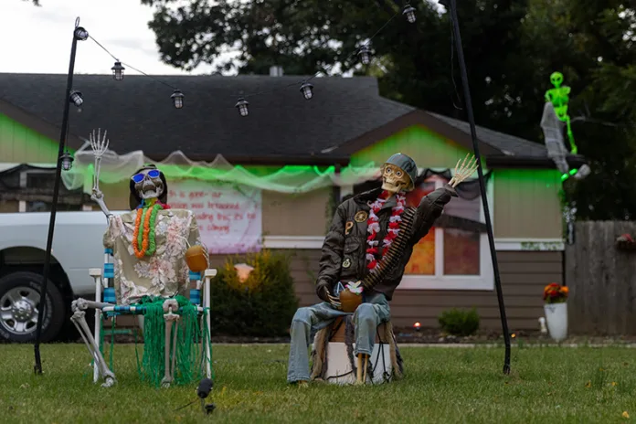 Two skeletons wave outside of a home near Riggs Lane and West 82nd Street in Overland Park.
