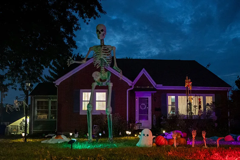 A giant skeleton is illuminated by colorful lights outside of a home near Park Street and Santa Fe Trail Drive in Lenexa.