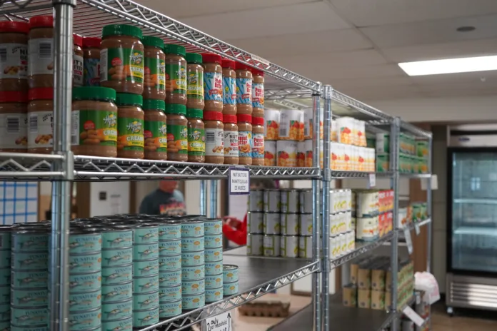 Metal shelves hold cans and jars of food.