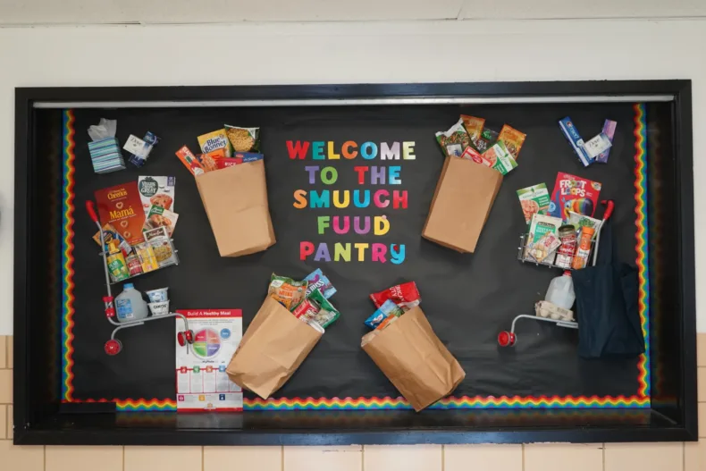 A sign reads "WELCOME TO THE SMUUCH FUUD PANTRY" in colorful letters.