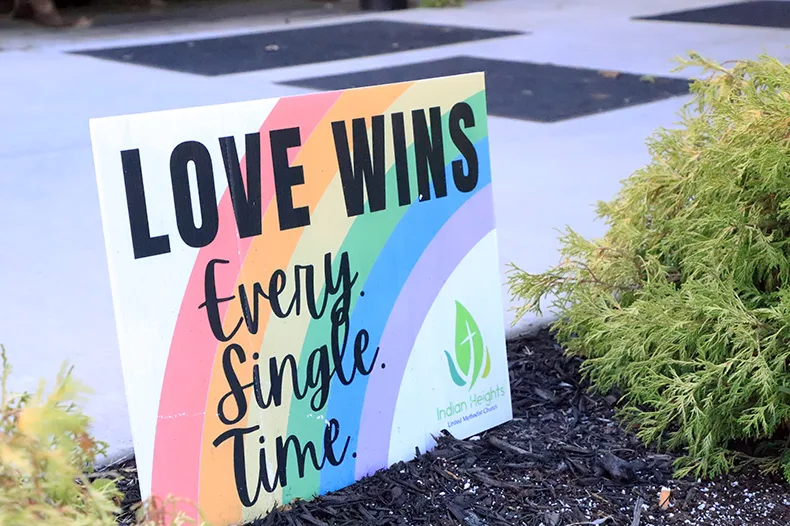 A small "Love Wins" yard sign posted near the front door of Indian Heights Methodist Church.