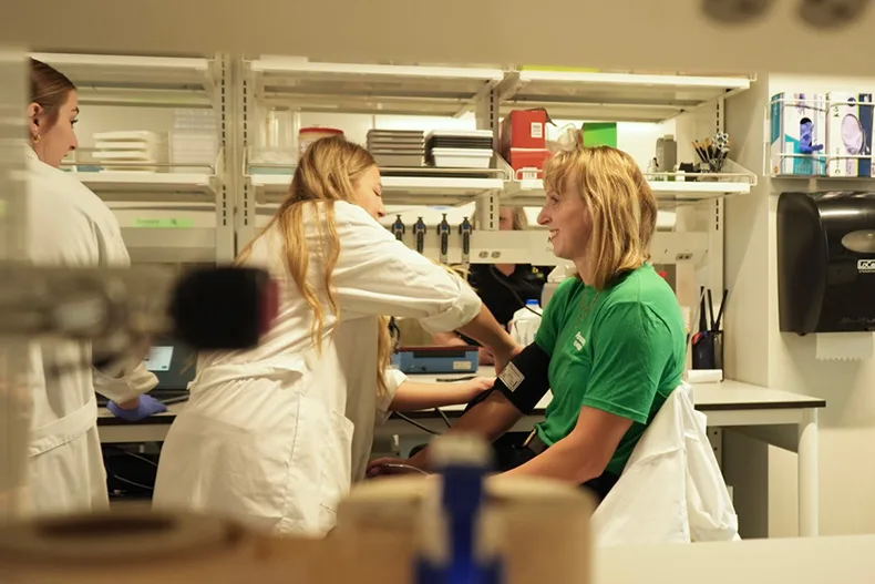 Mill Valley High senior Kate Dresvyannikov (center) takes Olympian Katie Ledecky’s blood pressure during an activity Sept. 30.