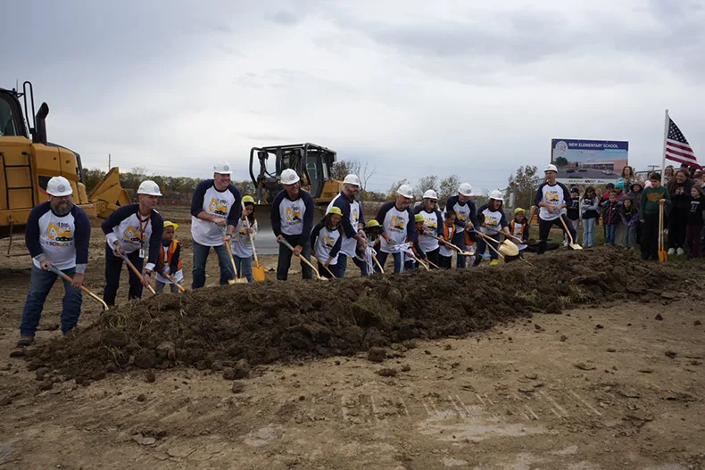 District officials, aided by elementary school students, break ground on a new elementary school just south of Pioneer Ridge Middle School.