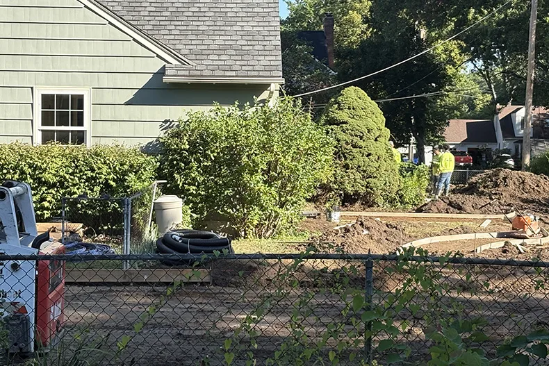 Construction of the side-yard pickleball court occurring in the lot neighboring Dana Wright and Johnny Yakle's new home in Overland Park.