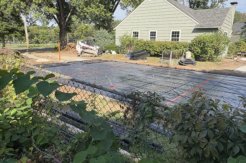 Construction of the side-yard pickleball court occurring in the lot neighboring Dana Wright and Johnny Yakle's new home in Overland Park.