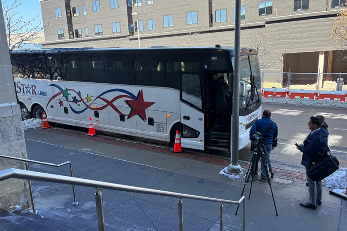 Journalists and public officials get a glimpse of the motor coach as an example of the type of bus the public transit system would use.