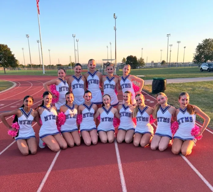 A group of cheerleaders pose for the camera.