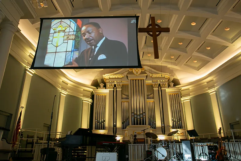 A 1967 NBC interview with Martin Luther King, Jr., played for the crowd at Village Presbyterian on Saturday afternoon. The interview is from 11 months before his assassination. Photo credit Juliana Garcia. 