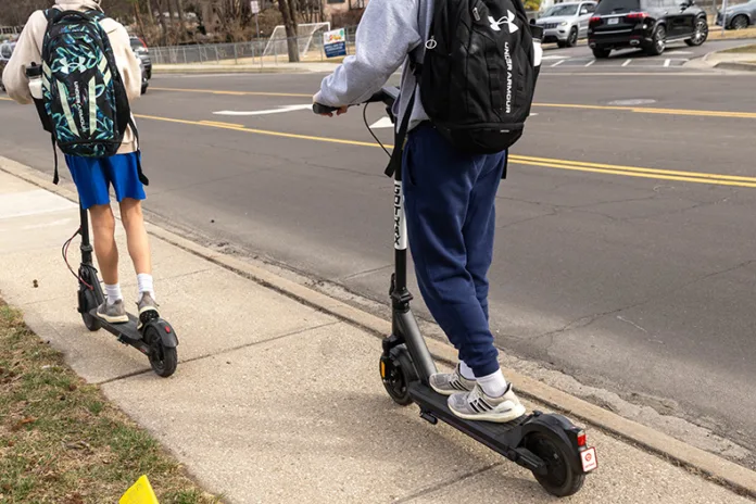 Two Corinth Elementary School students ride electric scooters after school on Tuesday, Feb. 24, in Leawood.