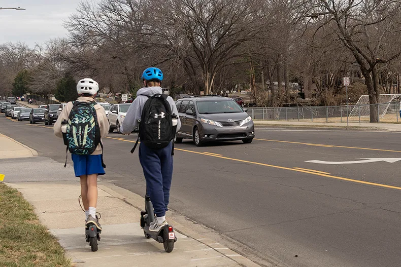 Two Corinth Elementary School students ride electric scooters after school on Tuesday, Feb. 24, in Leawood.