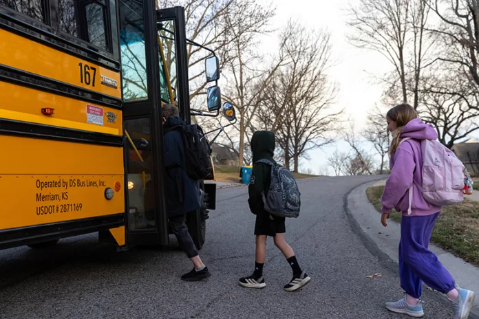 From left, fifth-grader Silas Trout, second-grader Shane Bosch and fourth-grader Ruby Bosch get on bus 167 for Rising Star Elementary School on Thursday, Feb. 19.