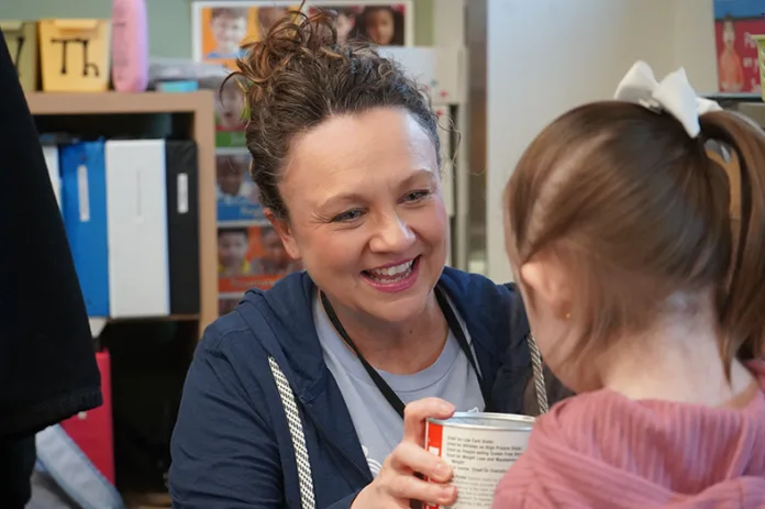 A woman smiles at a child.