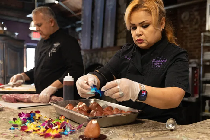 Chef Vicky Lara decorates a red wine poached pear before a Valentine’s Day dinner on Thursday, Feb. 12 at the Culinary Center of Kansas City in Overland Park.