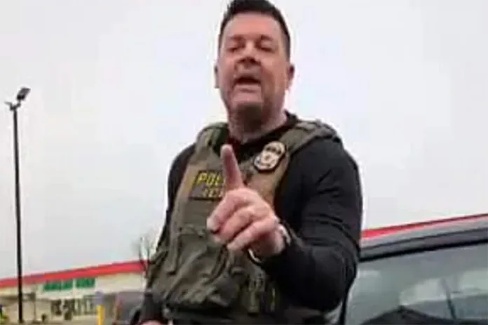 A screenshot of a video showing an ICE agent warning an observer.