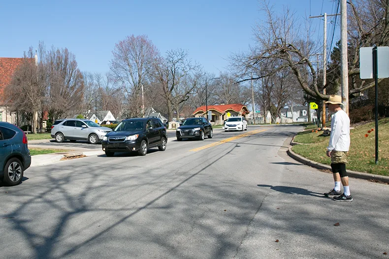 A pedestrian waits to cross to the north side of 53rd Street from Canterbury Road. Photo credit Juliana Garcia. 