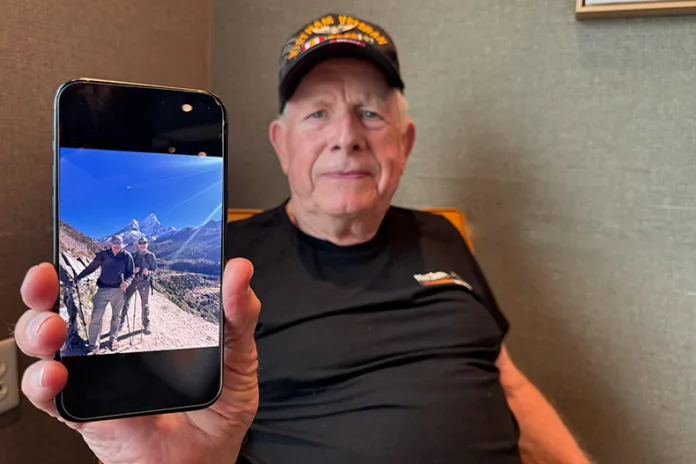 Dave McClung shows a photo of him and his son, Dennis McClung, at Mount Everest's base camp.
