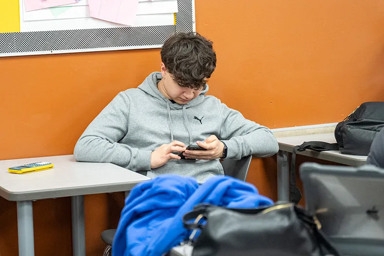 A student using a cell phone at Shawnee Mission Northwest High School.
