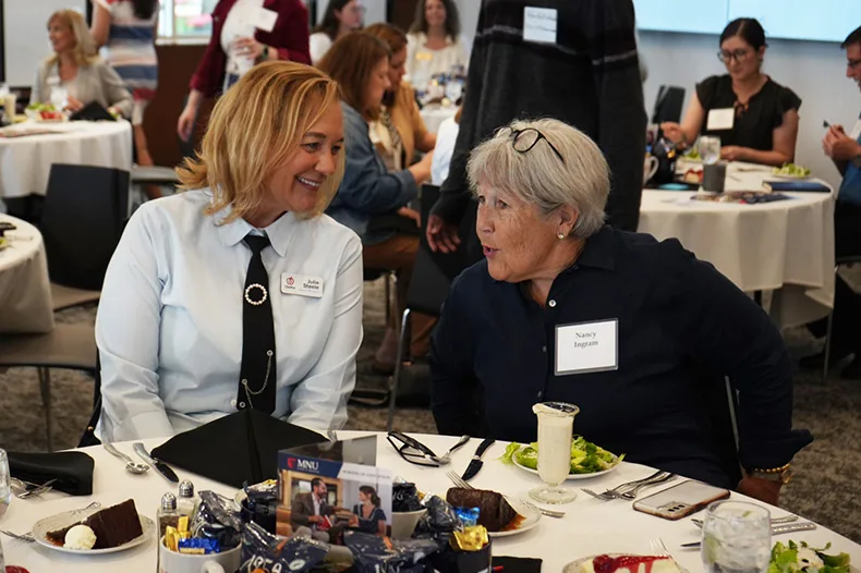 Olathe Board of Education Vice President Julie Steele (left) chats with former Johnson County Community College Trustee Nancy Ingram at the educators luncheon.