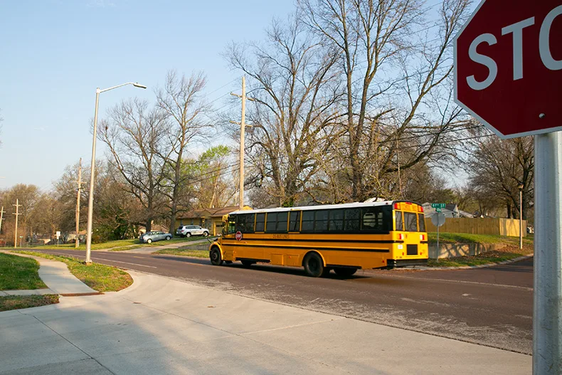 A school bus drives westbound on 87th Street near the Goodman Street intersection on a Monday morning in April. speed cushions. Photo credit Juliana Garcia.