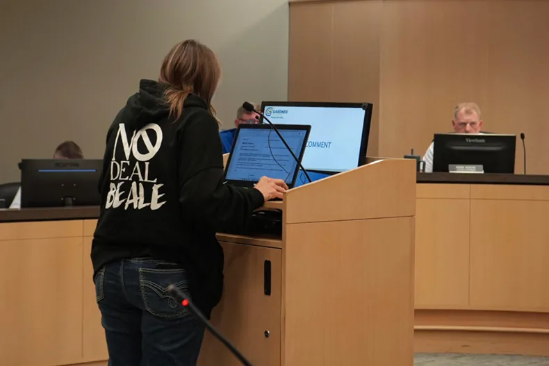 Gardner resident Carrie Schmidt wears a sweatshirt with the words, “No deal Beale,” while she speaks against the data center proposal Monday night.