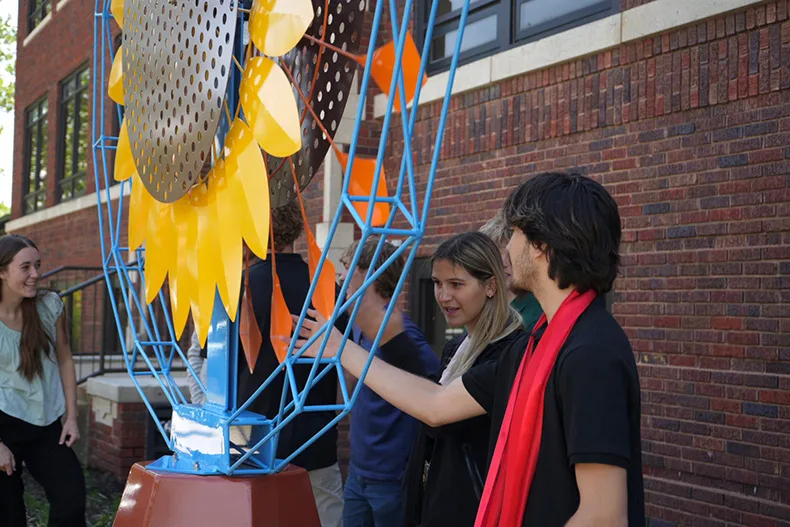 Mill Valley senior Gavin Wilson, a manufacturing and welding Cedar Trails Exploration Center student, moves one of the pieces of the kinetic sunflower sculpture. More than 30 students have worked on the project since it was first commissioned in 2024.