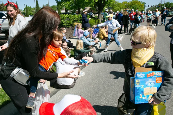 A child hands out candy to the crowd during Prairie Village's 75th Anniversary parade on May 2. Photo credit Juliana Garcia.