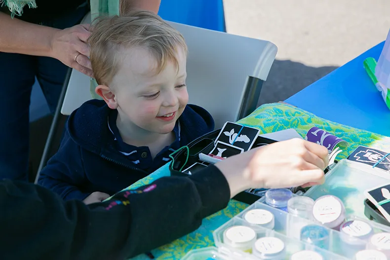 A young child picks out a glitter tattoo at one of the vendors on Saturday morning. Photo credit Juliana Garcia. 