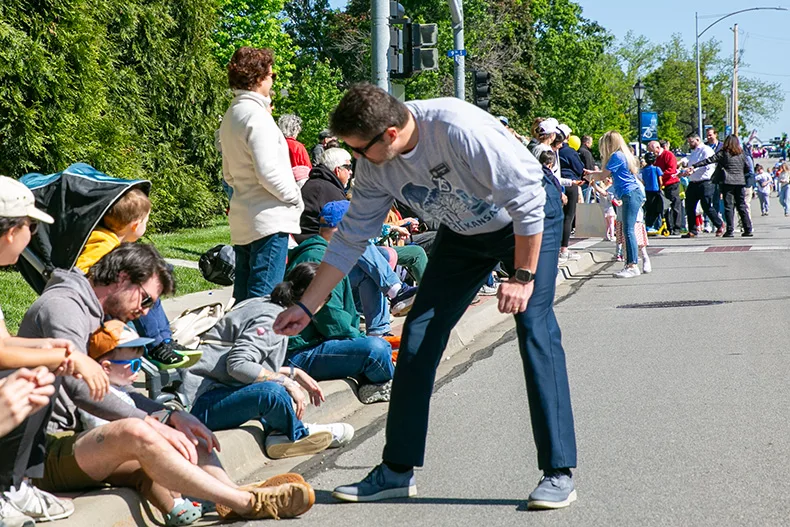 Mikkelson hands candy to a young child near 79th Street during the parade. Photo credit Juliana Garcia. 