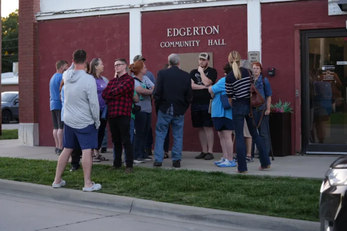 Residents from Edgerton and nearby communities stand and chat in front of Edgerton City Hall while the city council met for an executive session Thursday night.