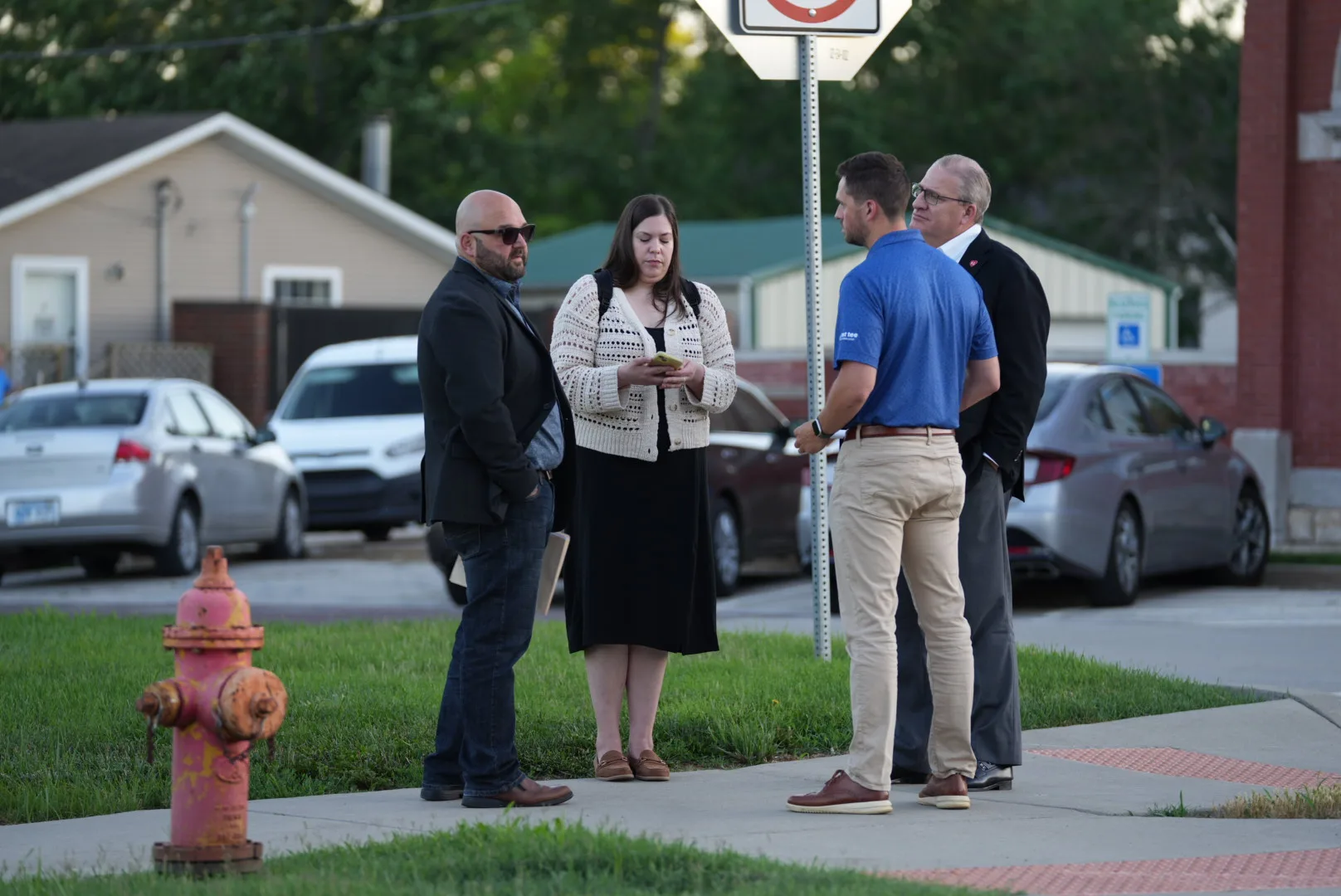 James Oltman (left), president of Elevate Edgerton, a public-private economic development partnership, chats alongside Chelsea Kulhanek (middle left), director of land acquisition for DAMAC Digital, and two others while waiting for the city council to reconvene after its executive session Thursday night.