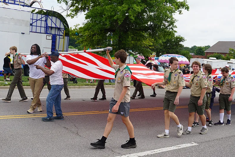 A group carries the American Flag in the Old Shawnee Days Parade. Photo credit Andrew Gaug.