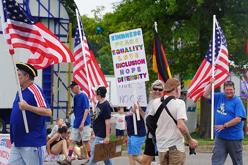 People hold signs for equality in the Old Shawnee Days Parade. Photo credit Andrew Gaug.