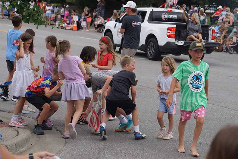 Kids grab candy at the Old Shawnee Days Parade. Photo credit Andrew Gaug.