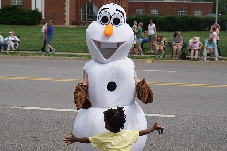 Olaf from "Frozen" gives a kid a hug in the Old Shawnee Days Parade. Photo credit Andrew Gaug.