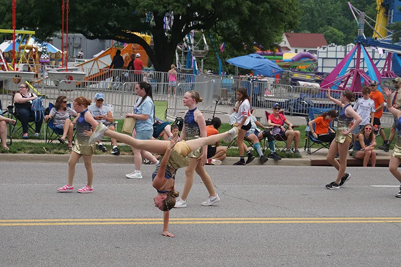 A dancer does a handstand in the Old Shawnee Days Parade. Photo credit Andrew Gaug.