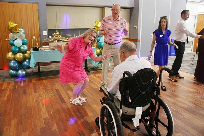From left, Joan Simoneau and Joe Simoneau dance with Vincent Jacks at the senior prom at Matt Ross Community Center on June 17.
