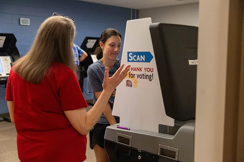 A volunteer helps an early voter on Thursday, July 30, at Hilltop Conference Center in Overland Park.