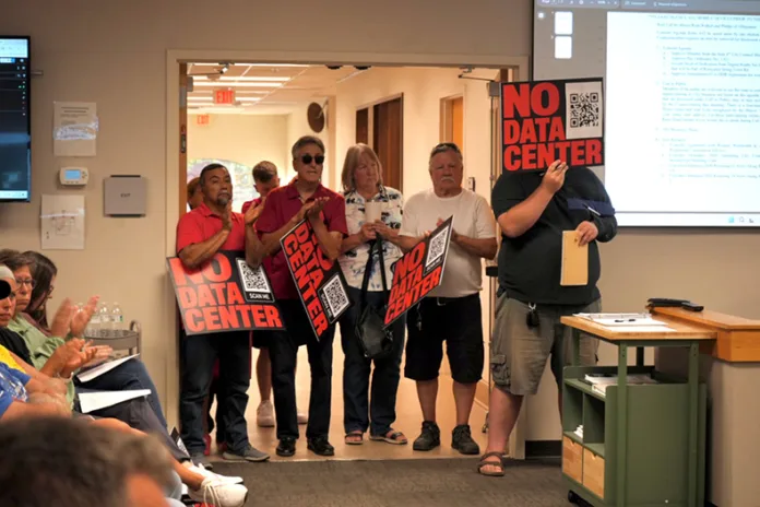 People cheer during the public comment period of the June 18 De Soto City Council meeting.