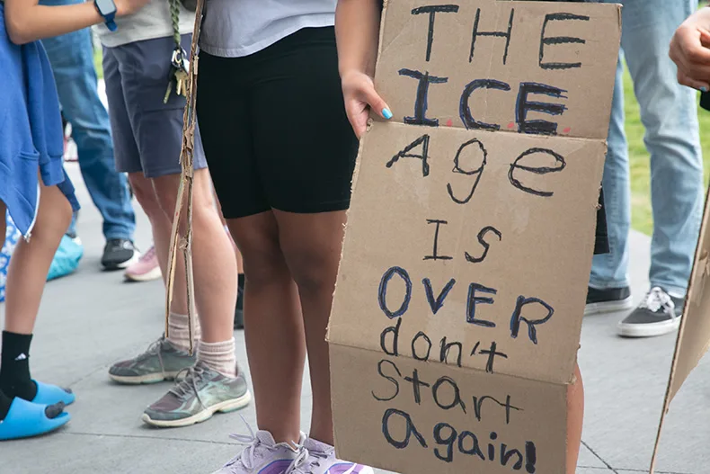 A sign held by a child reads "The ICE age is over, don't start again." Photo credit Juliana Garcia.
