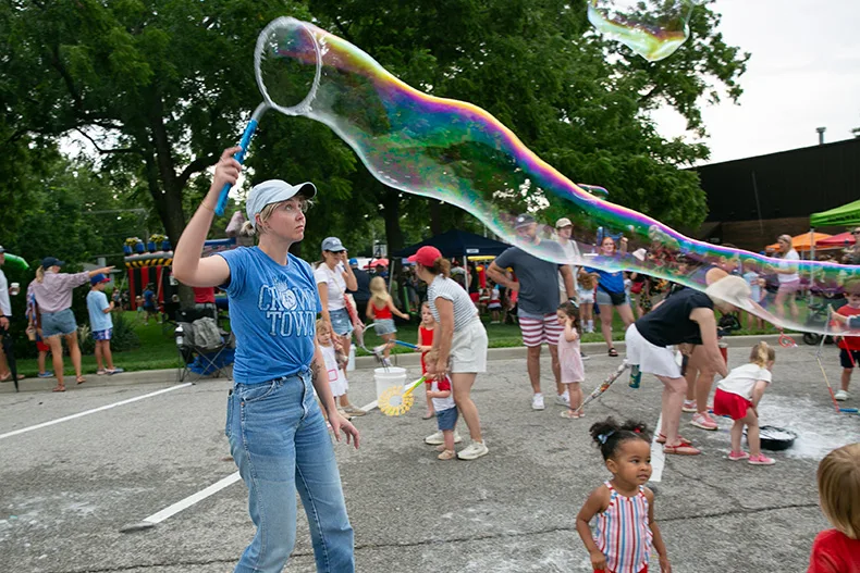 Adults also enjoyed the free activities at VillageFest, including the bubble station. Photo credit Juliana Garcia. 