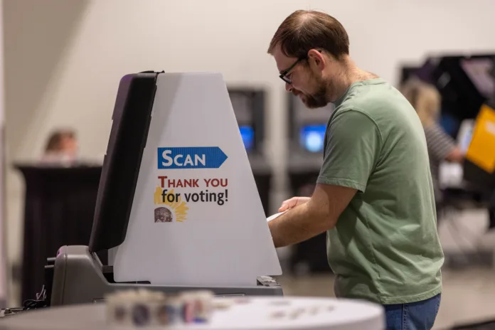 A voter scanned his ballot at the Johnson County Arts & Heritage Center in Overland Park on Tuesday, Aug. 4, 2026.