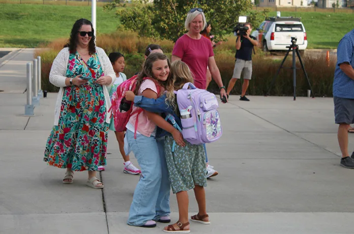 Students greet each other outside Prairie Creek Elementary on the first day of school.