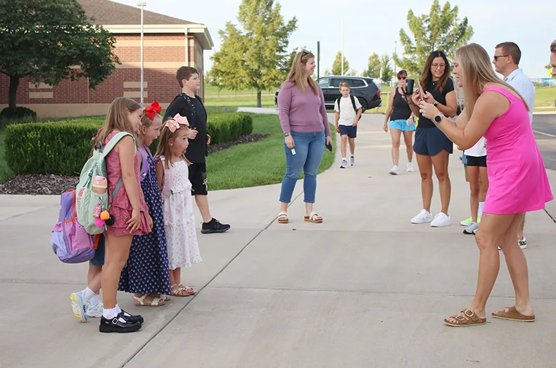A group of kids get their picture taken in front of Prairie Creek Elementary on the first day of school.